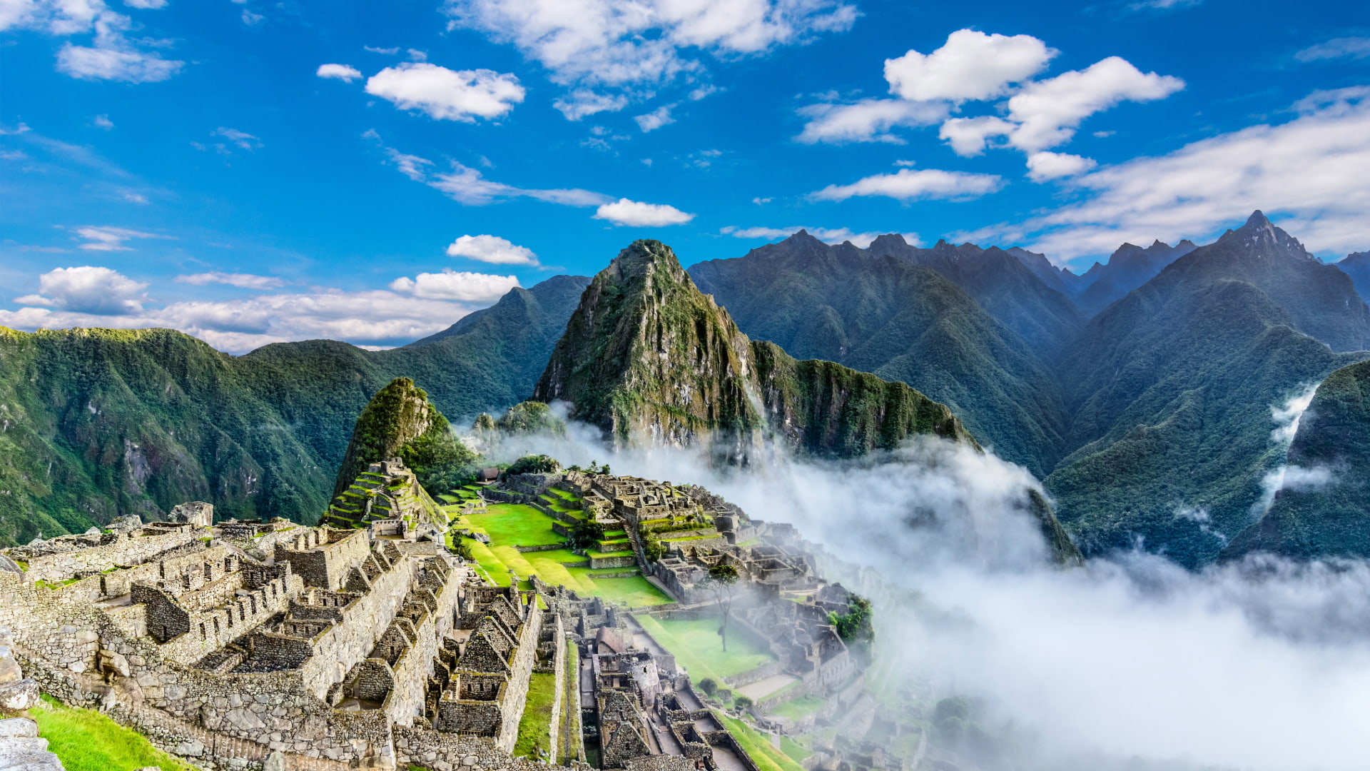 Panoramic view of Machu Picchu with Huayna Picchu mountain and clouds - Peru Hikers
