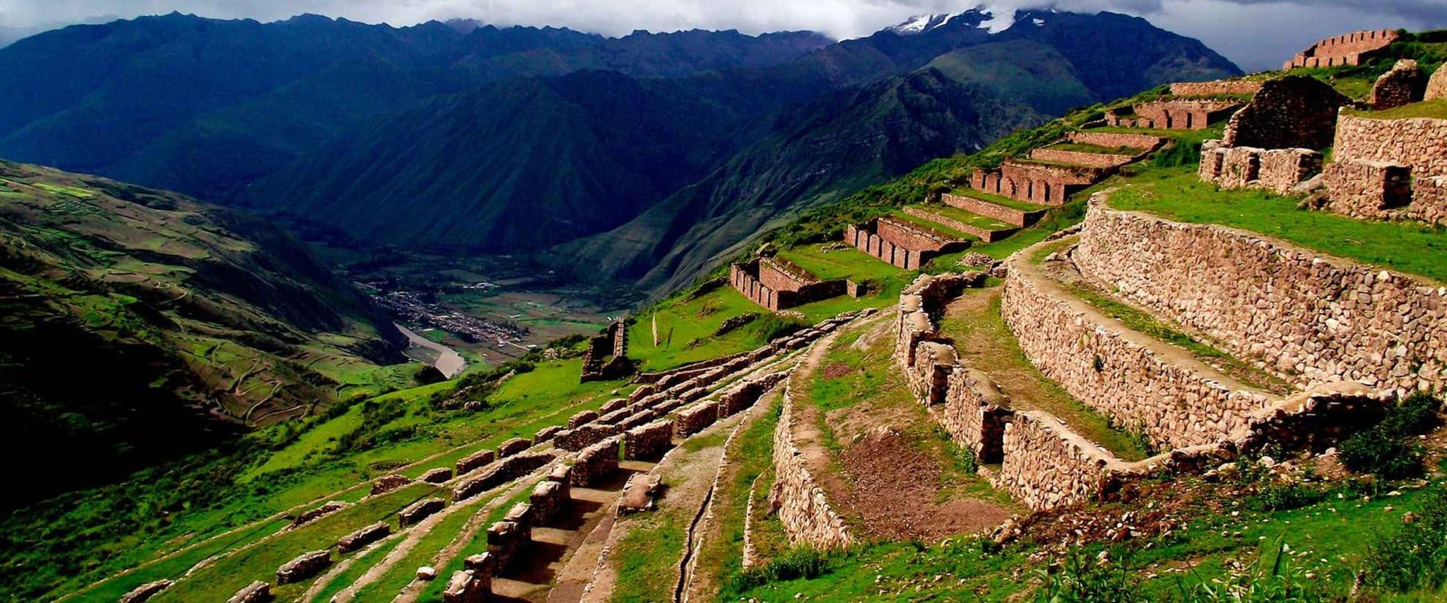 View of Pisac's Inca ruins, a key destination for Sacred Valley cultural experiences, with terraces overlooking the Andes - Peru Hikers