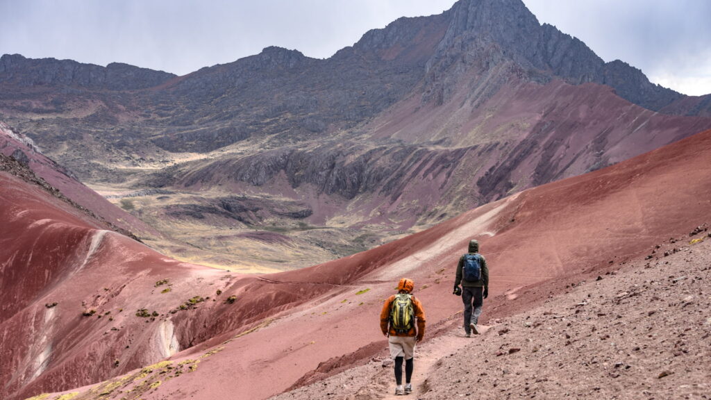 Two hikers exploring a colorful mountain landscape, a reward for dedicated training for high altitude trekking in Peru - Peru Hikers