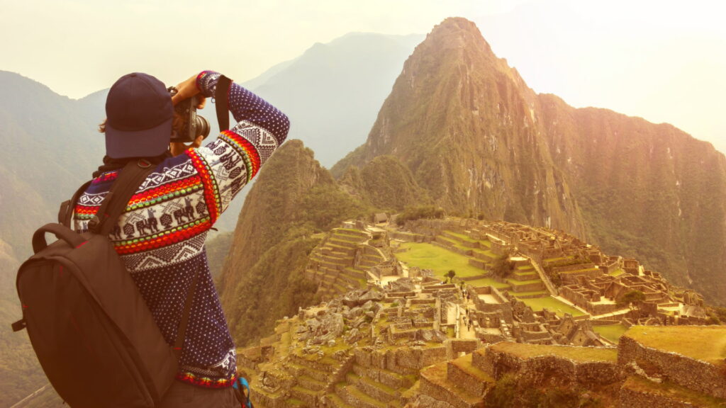 A photographer taking a picture of Machu Picchu at sunrise, a key moment in Inca Trail photography - Peru Hikers.