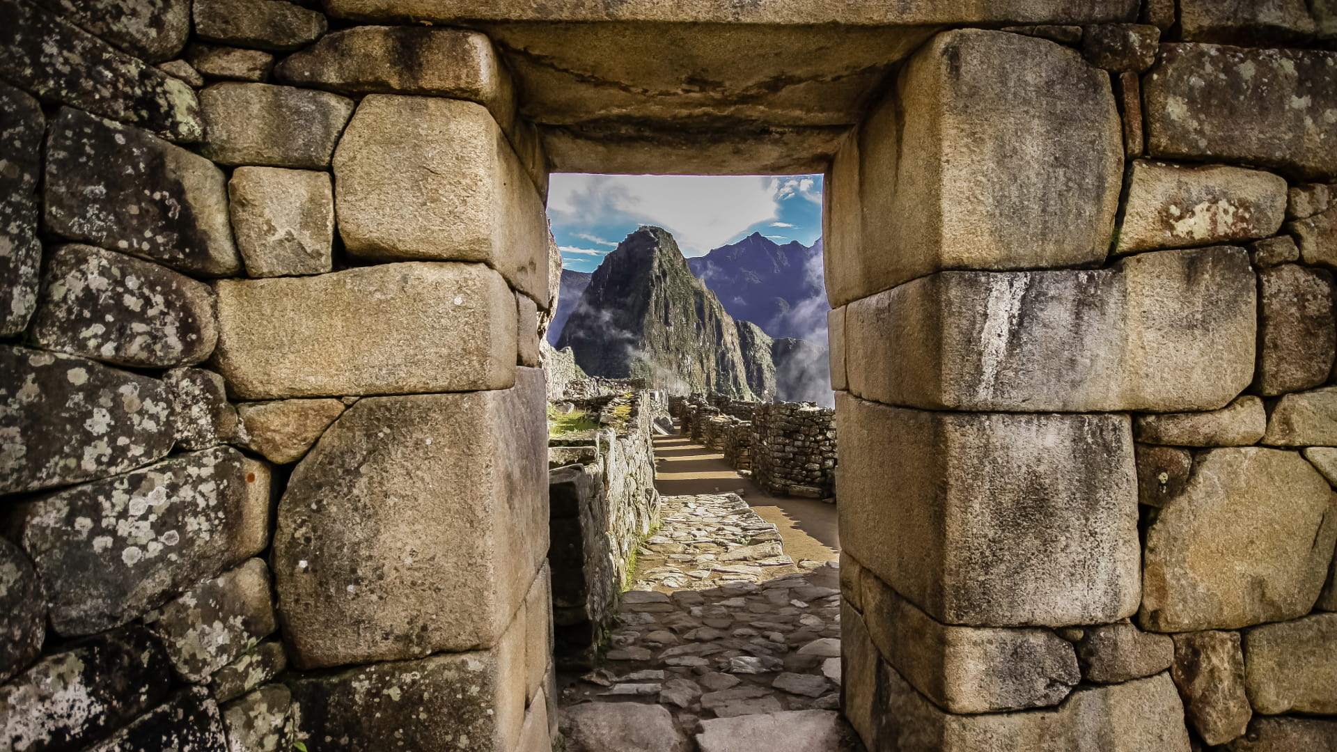 View of Huayna Picchu framed by an ancient Inca stone gateway in the Machu Picchu citadel - Peru Hikers.
