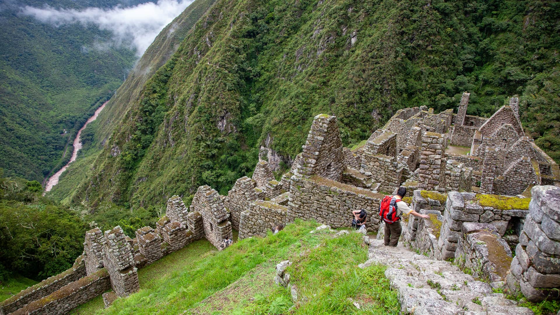 Trekkers exploring the Wiñay Wayna ruins on the Inca Trail, known as Peru's most famous trek, with the Urubamba valley below.
