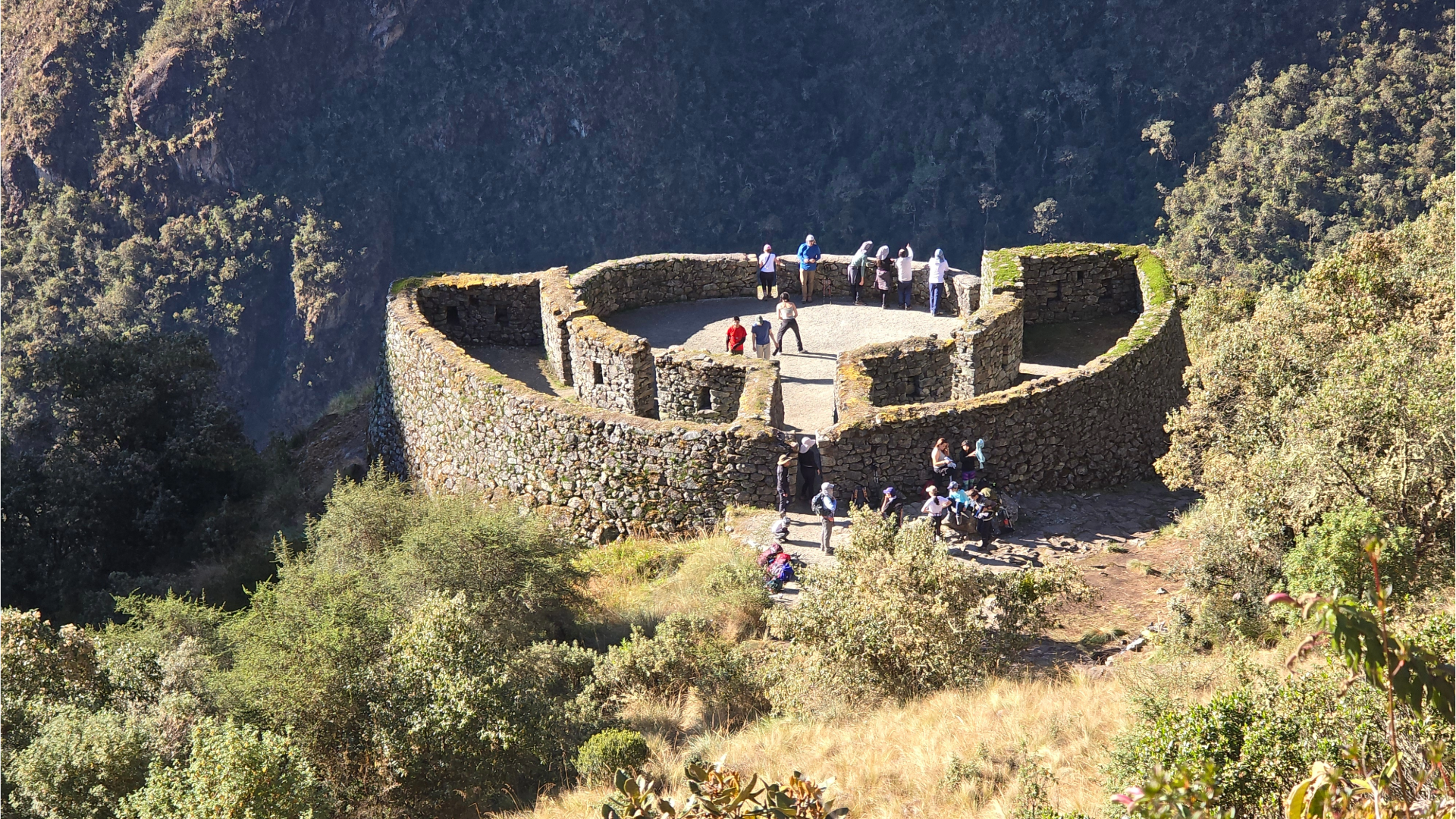 Group of trekkers exploring the circular stone ruins of the Runkuracay archaeological site on the Classic Inca Trail - Peru Hikers.