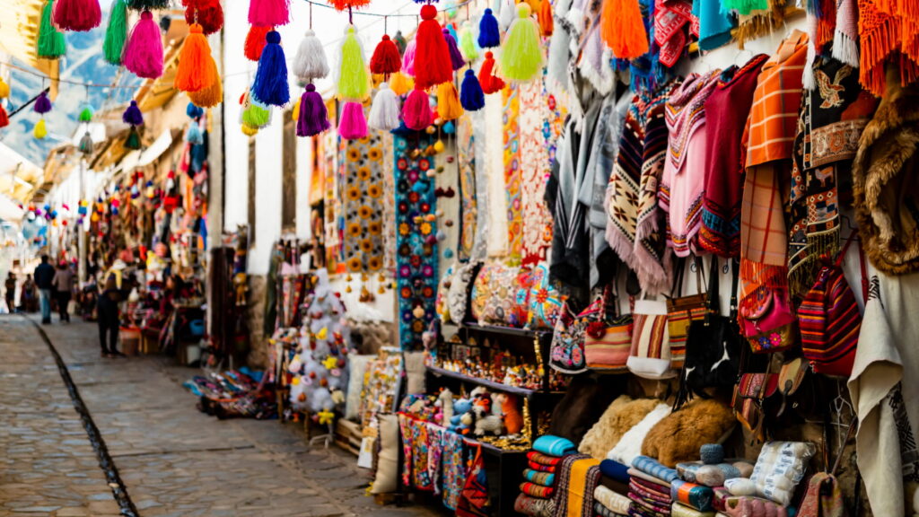 Colorful artisan market stall, a vibrant part of the Sacred Valley cultural experiences, displaying traditional Peruvian textiles - Peru Hikers