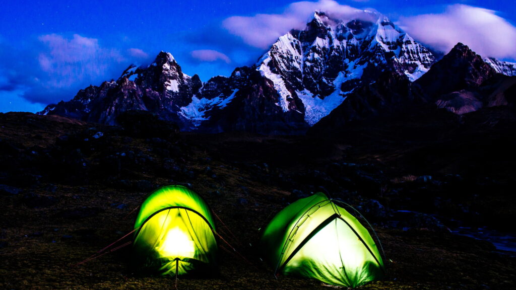 Illuminated tents under a starry sky on the challenging Ausangate trek - Peru Hikers