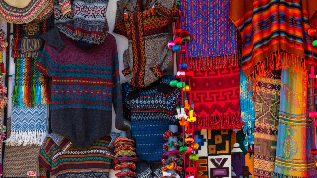 Close up of traditional alpaca sweaters and blankets, showcasing the best souvenirs from Cusco textiles - Peru Hikers