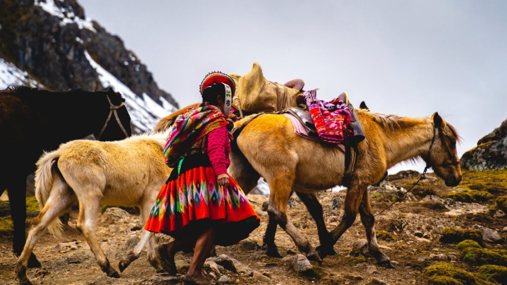 A smiling Peruvian porter carrying a load on the Inca Trail. Tipping in Peru is a cultural necessity that supports trekking staff - Peru Hikers