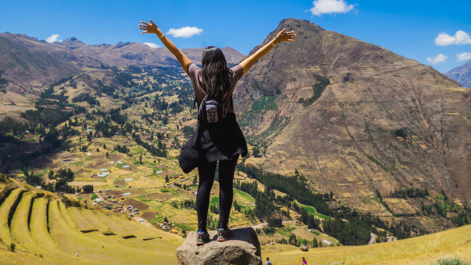 Solo female traveler with arms outstretched at the Machu Picchu viewpoint, symbolizing a secure and successful solo female travel peru safety experience.