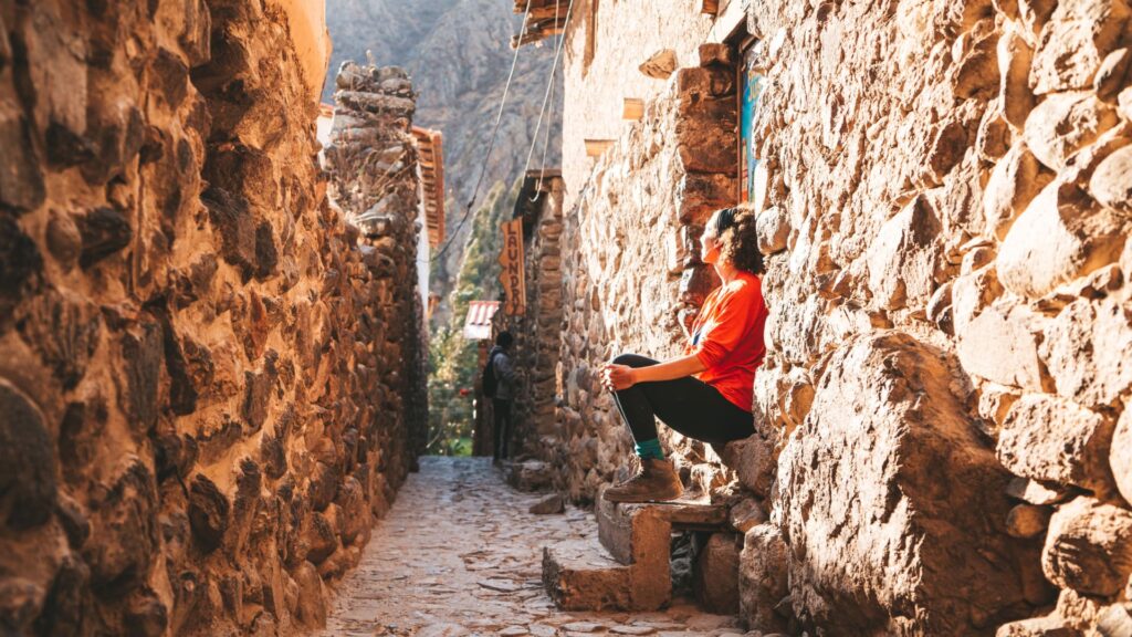 A hiker resting in a stone alley in an Andean village, a key step for successful inca trail altitude acclimatization - Peru Hikers