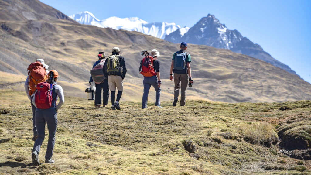 A Peru Hikers guide assisting a trekker on a steep section of the Inca Trail, demonstrating the support provided as part of the emergency protocol and safety measures.
